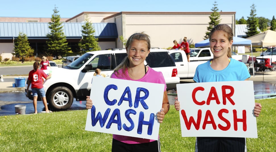 School kids running a car wash fundraiser