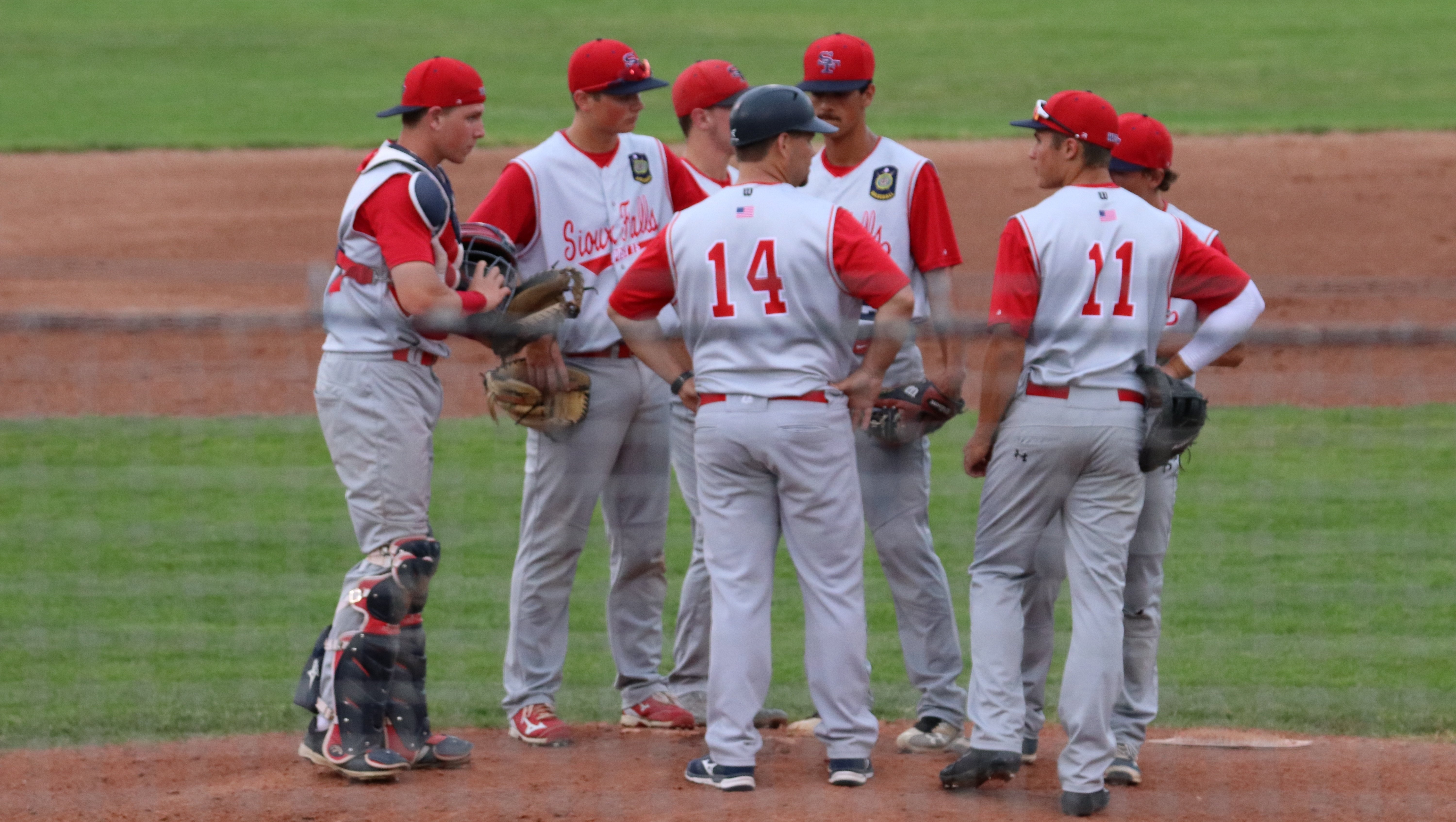 Sioux_Falls_Baseball_Team_huddled_around_the_pitching_mound