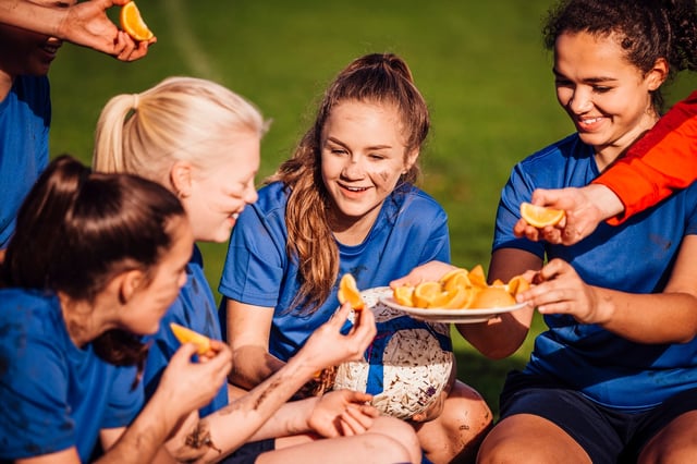 soccer_team_enjoying_snack_of_orange_slices